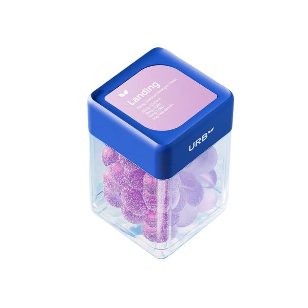 A clear container with a blue lid holds purple sleeping gummies. The label on the lid reads "Urb Landing" and lists ingredients and nutritional information, including melatonin for better sleep.