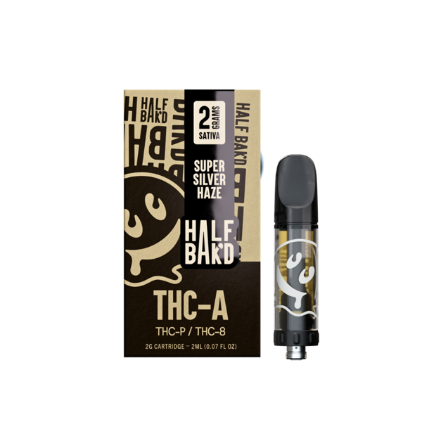 A Half Bak'd Half Bak'd THC-A Cartridge | 2g in Super Silver Haze flavor, containing 2 grams of Sativa and compatible with 510 vape batteries. The black and gold box, along with the cartridge, features a smiling face logo. Enjoy a premium THC-A live resin experience.