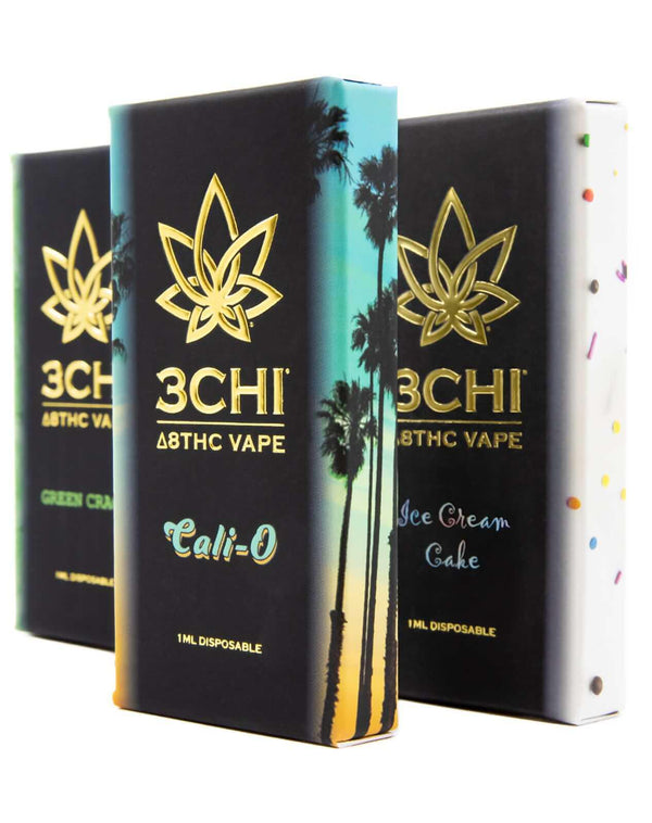 Image showcasing three 3Chi Delta 8 Disposable Vape boxes labeled "Green Crack," "Cali-O," and "Ice Cream Cake." The hemp-derived boxes feature distinct designs, including a palm tree and ice cream-themed patterns.